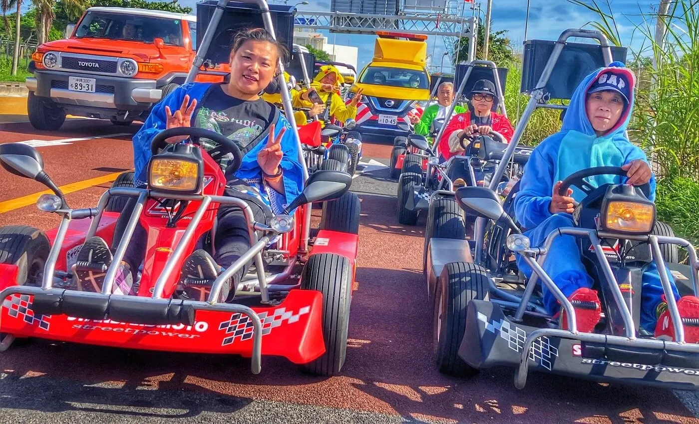 A line of go karts waiting in traffic on a red-surfaced bus lane in central Naha