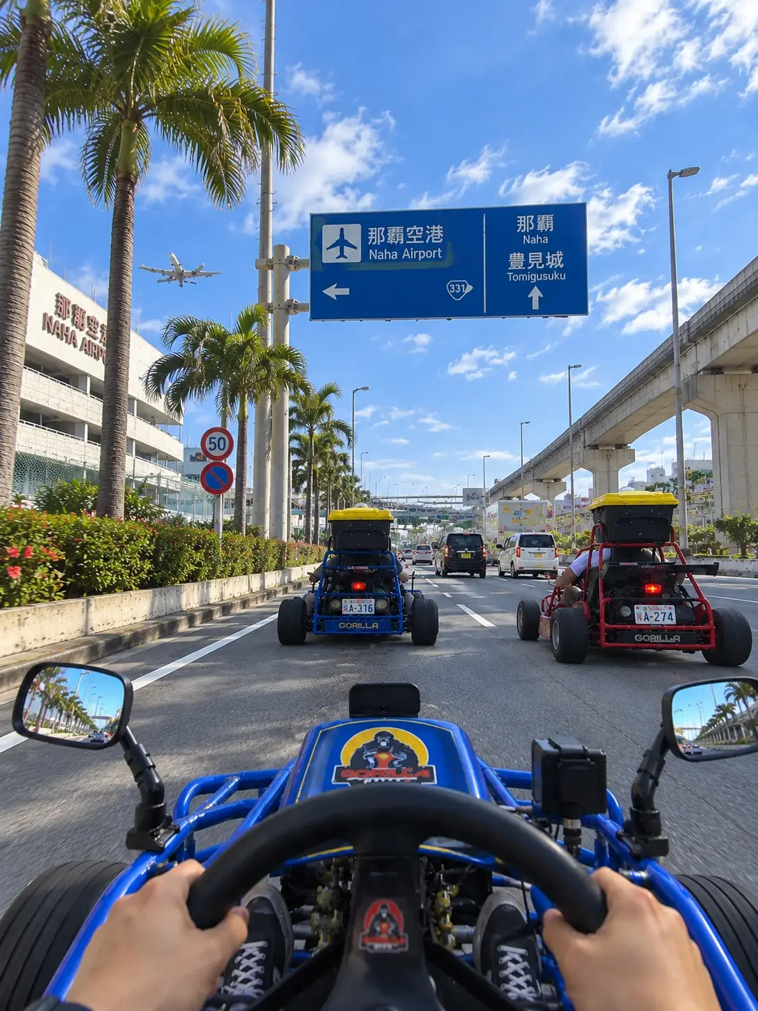 La vista desde detrás del volante de un kart de Gorilla Kart, conduciendo hacia el aeropuerto de Naha con dos karts más delante, bajo el monorraíl y las palmeras