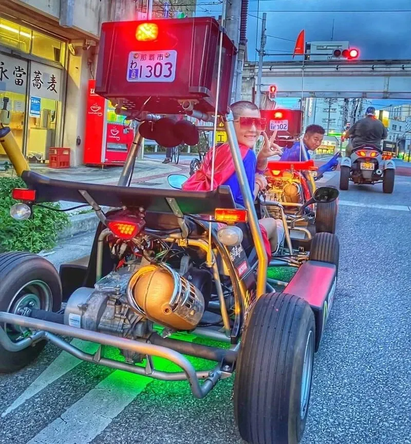 Close-up of a Gorilla Kart's exposed engine and roll bar at a city junction after dark